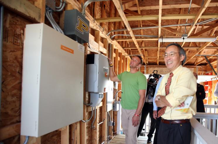 Secretary Chu speaks with student team member Jordan Wallpe as he demonstrates the inverter system showcased in Purdue University's garage at the 2011 Solar Decathlon. | Credit: Stefano Paltera, U.S. Department of Energy Solar Decathlon